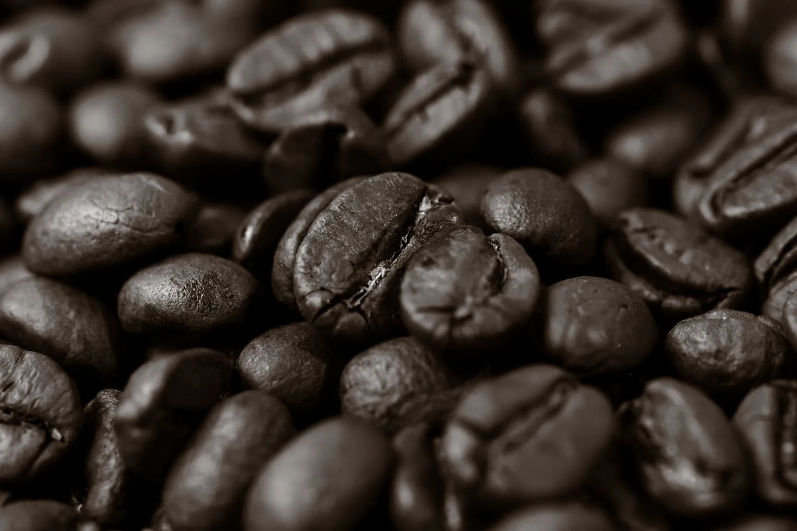 Detailed close-up of roasted coffee beans, highlighting texture and rich brown color.